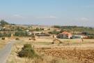Vista panorámica tomada desde lo alto de la carretera, donde se aprecian varias casetas en la era donde se guardaban los aperos de labranza